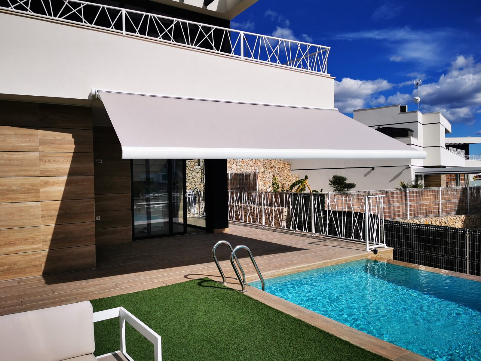 Toldo cofre motorizado con sensor de viento junto a piscina en Orihuela Costa