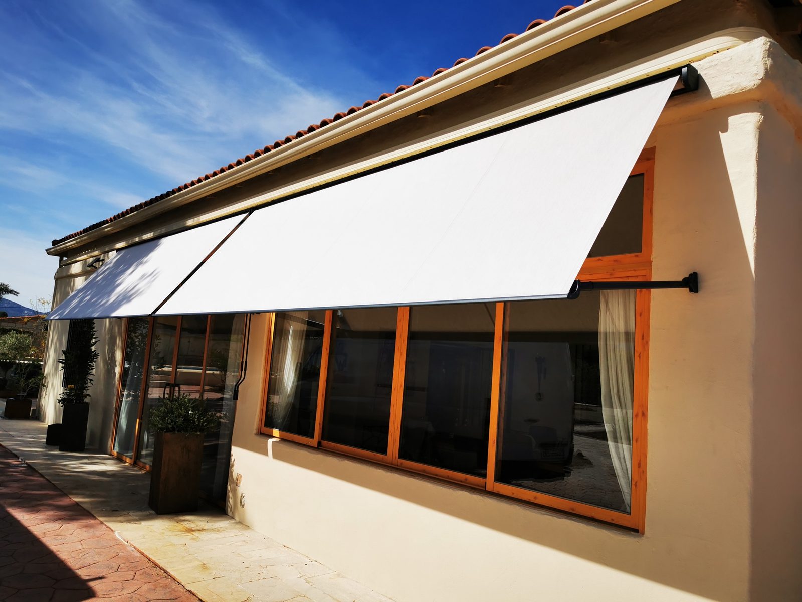 Toldo cofre motorizado en terraza con jardín instalado en Alicante