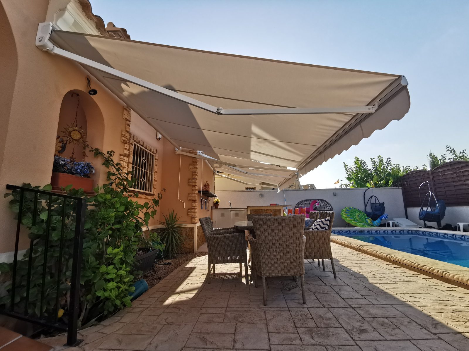 Toldo extensible de brazo instalado junto a piscina en villa de Guardamar